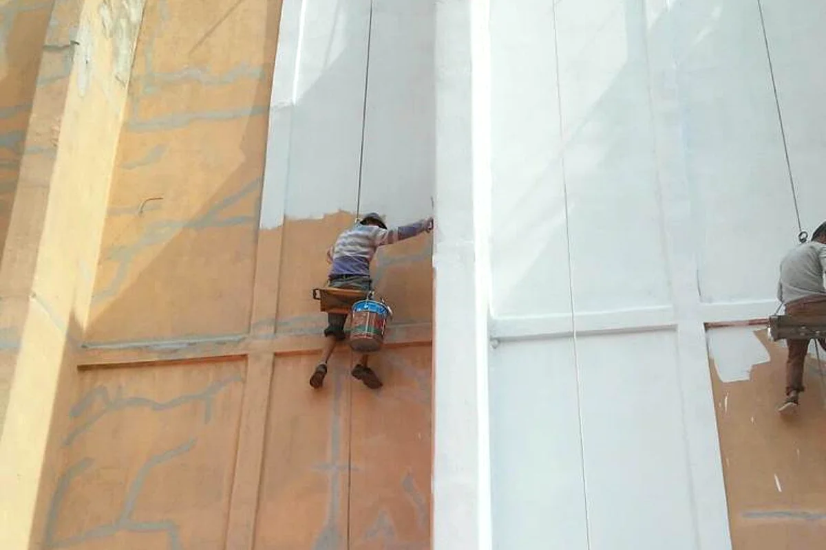 Aplicadores en rapel impermeabilizando un muro exterior